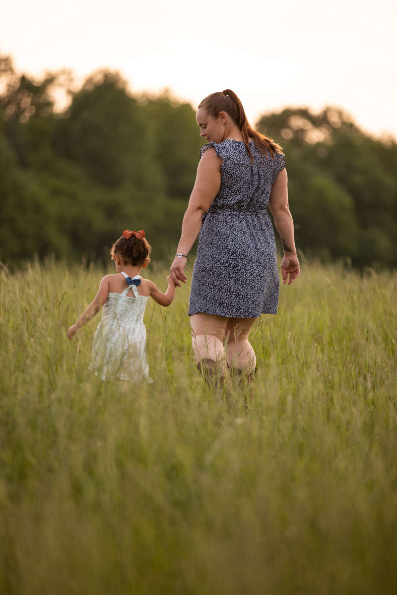 Mom and child walking in field